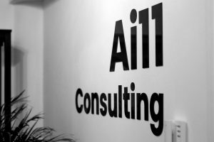 Das Ai11-Logo wird prominent an der Bürowand angezeigt und repräsentiert unsere Markenpräsenz und unser Engagement für Innovation.